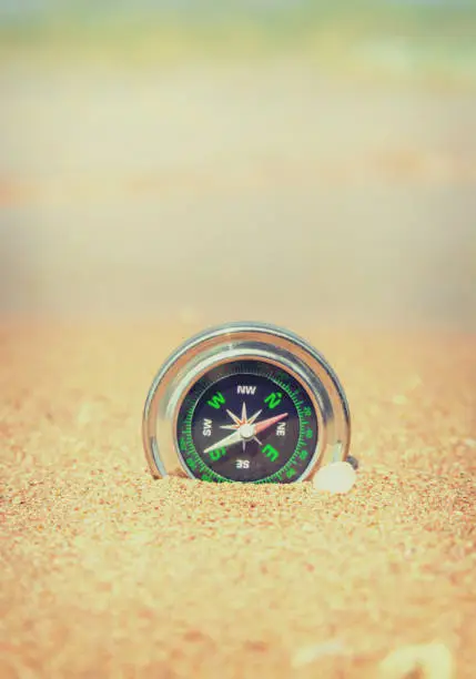 Photo of compass on the sea coast. Selective focus.