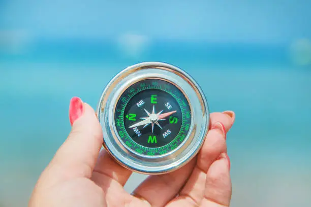 Photo of compass on the sea coast. Selective focus.