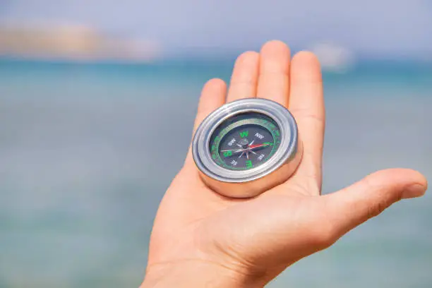 Photo of compass on the sea coast. Selective focus.