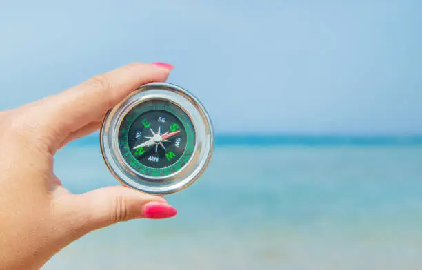 Photo of compass on the sea coast. Selective focus.