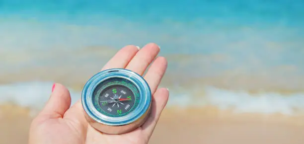 Photo of compass on the sea coast. Selective focus.