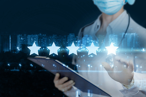 The concept rating of medical care. The doctor clicks a star on the blurred background of the city.