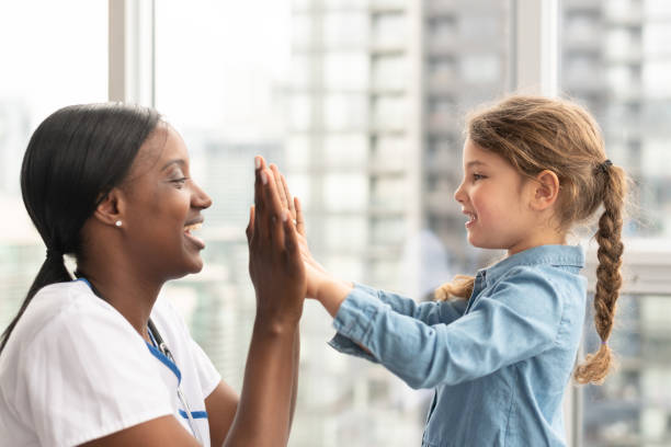 istock Child patient playing patty cake with doctor 1165575972