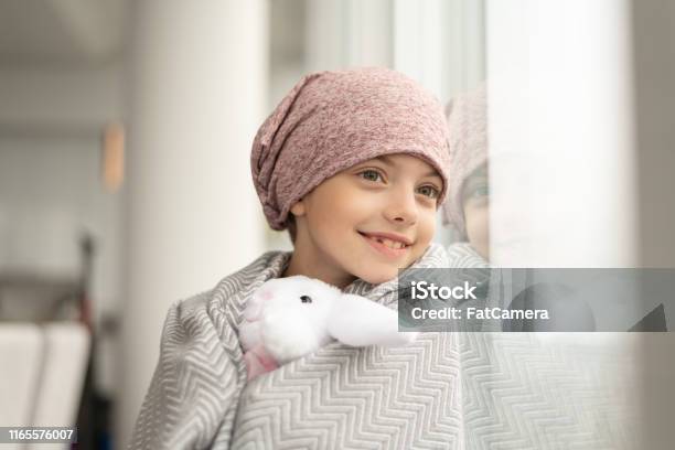 Smiling Girl With Cancer Looks Out Window Stock Photo - Download Image Now - Child, Cancer - Illness, Patient