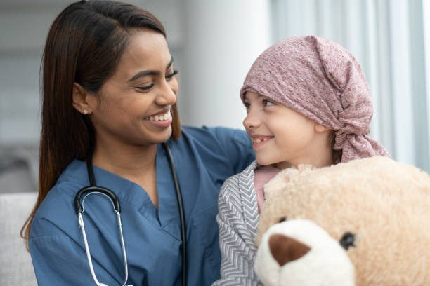 istock Kind doctor comforts girl with cancer 1165576014