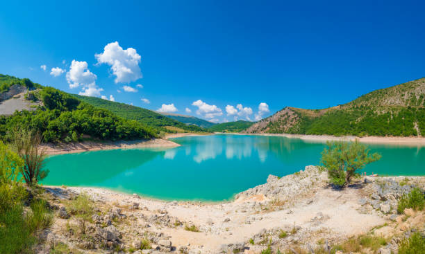 Fiastra lake and Lame Rosse canyon (Marche, Italy) Fiastra, Italy - 20 July 2019 - Fiastra lake and Lame Rosse canyon, a naturalistic wild attraction in the Monti Sibillini National Park, province of Macerata, Marche region, central Italy. Here in particular the lake with people macerata italy stock pictures, royalty-free photos & images
