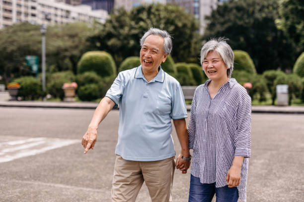 istock Senior couple walking in the park 1165579059