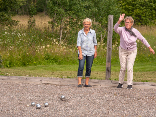 istock Two elderly retired pensioner women playing boule in the sun being active 1165579815