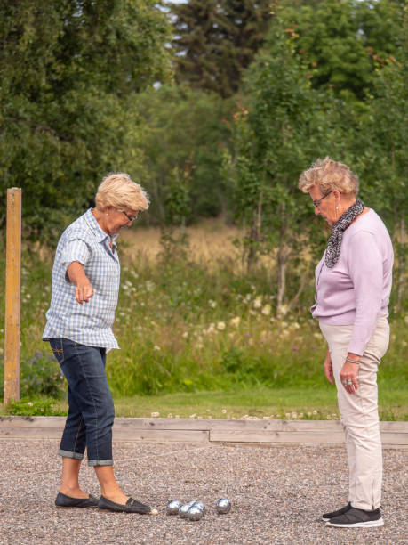 istock Two elderly retired pensioner women playing boule in the sun being active 1165579911