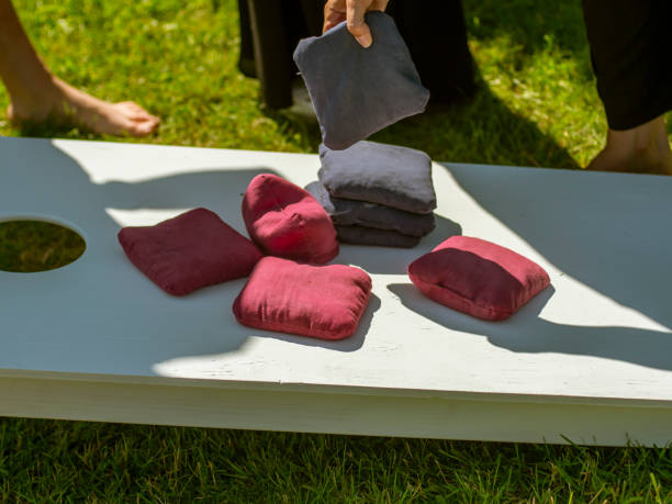 plateau de jeu de cornhole avec les sacs rouges et bleus de maïs sur une pelouse verte d'été d'herbe - cornhole leisure games outdoors color image photos et images de collection