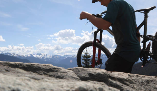 istock Mountain biker carries bikes over rocky terrain 1165583331