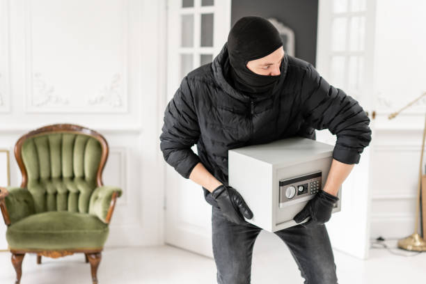 ladrão com balaclava preto que rouba a caixa segura eletrônica moderna. o ladrão comete um crime em apartamento de luxo com estuque. - night deposit box - fotografias e filmes do acervo