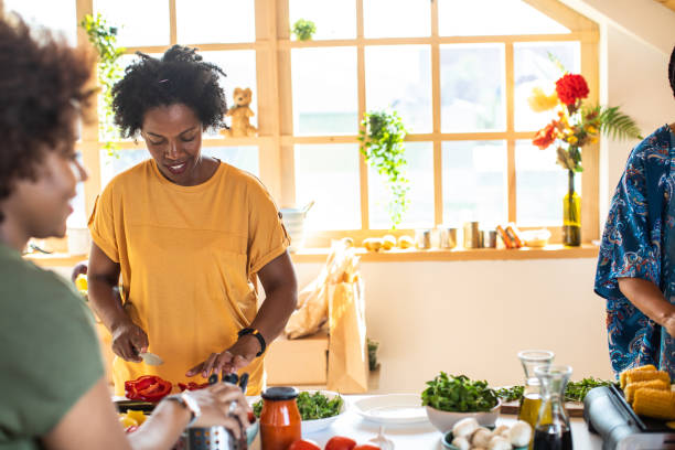 istock African woman making lunch with friends 1165583534