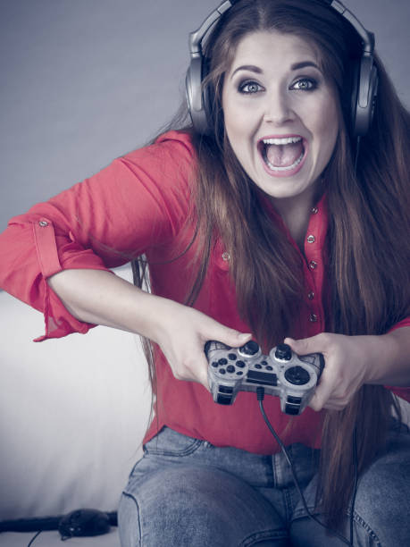 istock Young woman playing video games 1165584564