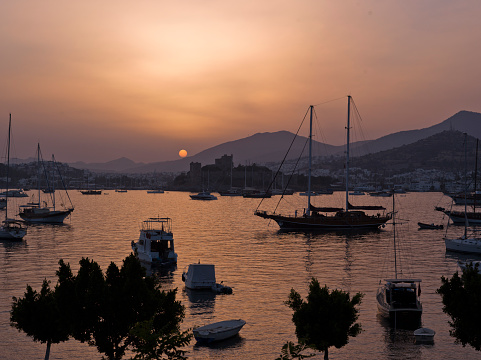 View of Bodrum, Aegean Sea and boats at sunset. Turkey, Muğla, Bodrum.