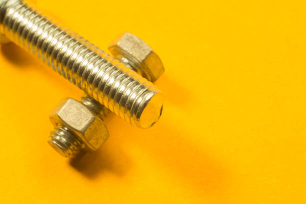 istock Steel screws on a yellow background 1165588513