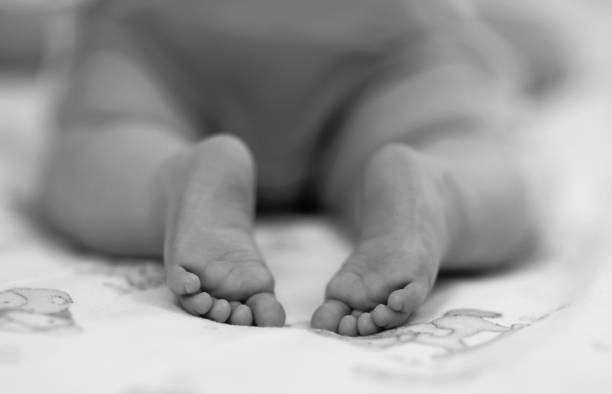 красивые маленькие ноги и ноги на детских ногах черно-белый вид сбоку крупным планом - human foot baby black and white newborn стоковые фото и изображения