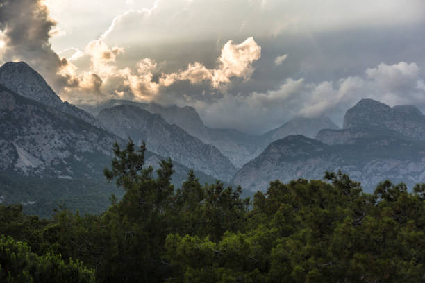 Wonderful clouds rising behind mountains and forests. Sunrise landscape in nature. Turkey, Antalya, the Taurus Mountains.