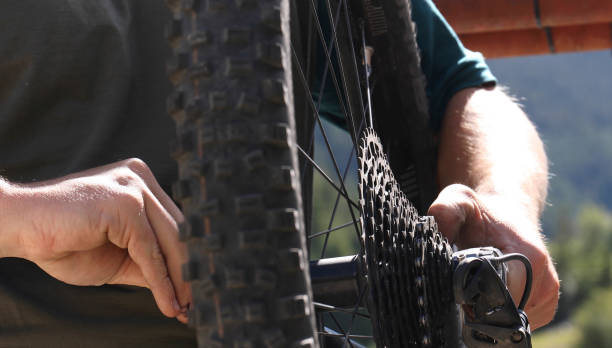 istock Close-up of mountain biker performs repairs 1165590148