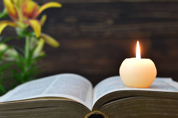 istock Candle, book and flowers on wooden background 1165595569