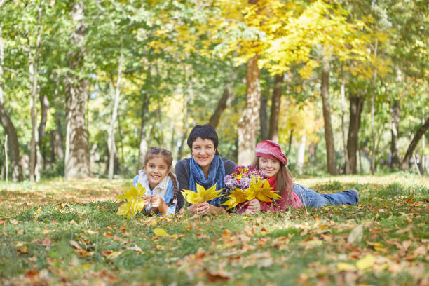 Buona famiglia. Amorevole madre e due figlie nel parco autunnale. - foto stock