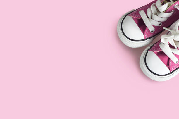 istock Pink baby sneakers on pink background with copy space 1165598656