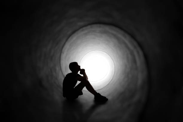 istock Teen Boy Praying in a Dark Place 1165599879