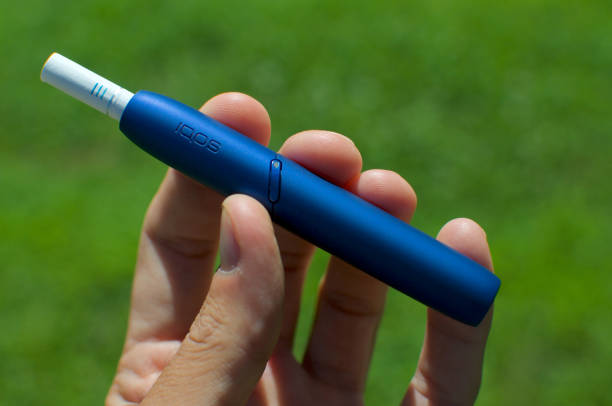 IQOS 3 electronic cigarette device with heat-not-burn system Caslano, Ticino, Switzerland - 26th July 2019 : Picture of the IQOS 3 version, a new heat-not-burn tobacco product technology produced by Philip Morris International in Neuchatel, Switzerland iqos e cig stock pictures, royalty-free photos & images