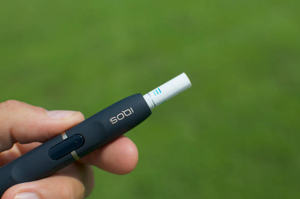 IQOS electronic cigarette device with heat-not-burn system Caslano, Ticino, Switzerland - 26th July 2019 : Picture of IQOS a new heat-not-burn tobacco product technology produced by Philip Morris International in Neuchatel, Switzerland iqos e cig stock pictures, royalty-free photos & images