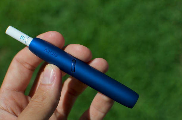 IQOS 3 electronic cigarette device with heat-not-burn system Caslano, Ticino, Switzerland - 26th July 2019 : Picture of the IQOS 3 version, a new heat-not-burn tobacco product technology produced by Philip Morris International in Neuchatel, Switzerland iqos e cig stock pictures, royalty-free photos & images