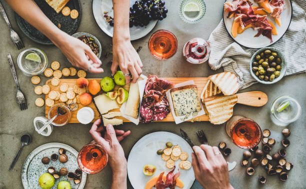 pique-nique d'été avec le vin de rose et les casse-croûte et les mains de peuples - salumeria photos et images de collection