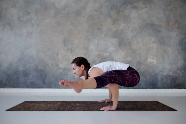 istock Woman doing handstand, variation of Firefly posture, Tittibhasana. 1165604223
