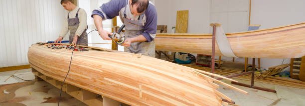 istock Young carpenters assembling wooden canoe 1165604979