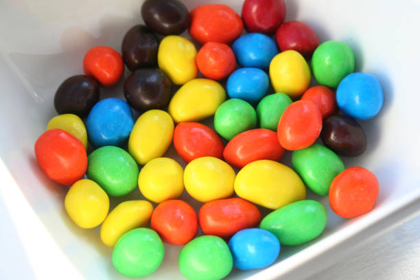 Colorful hard peanut chocolate candy in a white dish, in colors of red green blue and brown