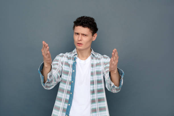istock Man isolated on gray wall free style standing looking camera gesturing confused unhappy 1165610563