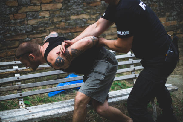 Under arrest A policeman manhandling a gang banger who is resisting arrest. drug addiction tattoos stock pictures, royalty-free photos & images