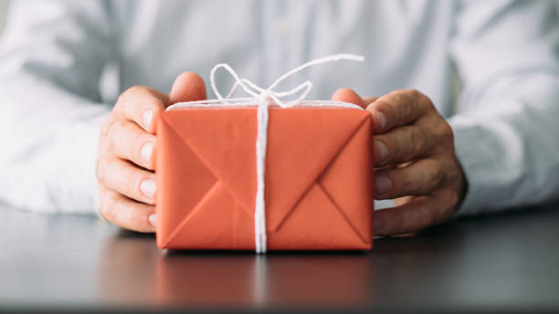 istock goods delivery service red gift box man hands 1165610818