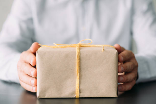 istock goods delivery service beige gift box man hands 1165610820