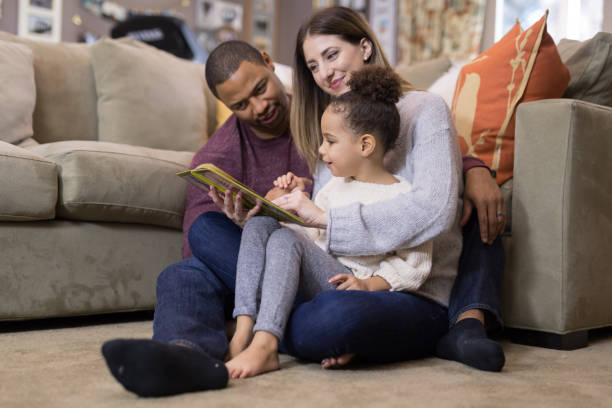 istock Mixed race family reading a book together 1165611142