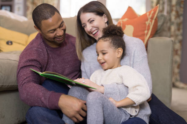 istock Mixed race family reading a book together 1165611145