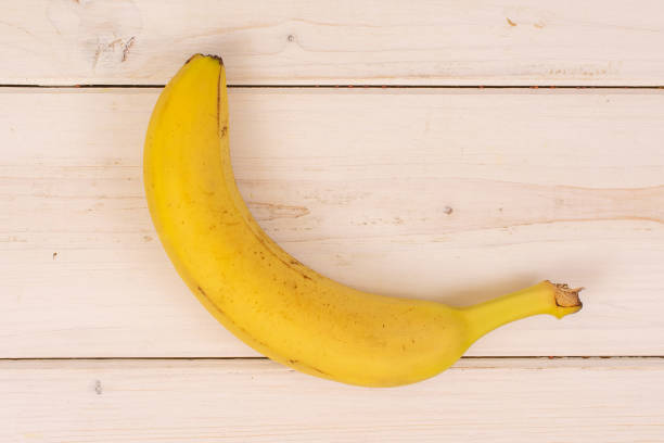 istock Ripe yellow banana on grey wood 1165613400