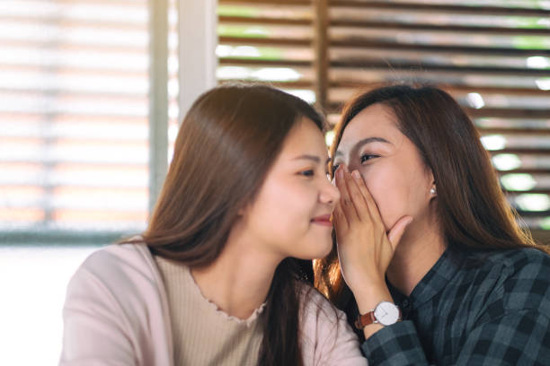 istock friends telling and gossiping the secret 1165626574