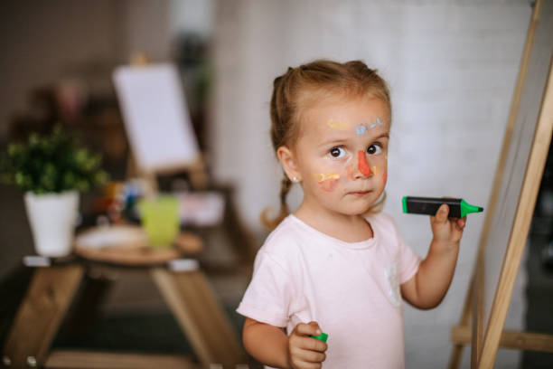 Cute little girl playing with watercolors at home