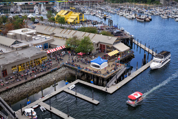 Aerial View of Granville Island, Vancouver, Canada Vancouver, Canada - June 23, 2019: Aerial view of Granville Island in summer on a cloudy afternoon, a ferry with canadian flag canopy approaching. granville island stock pictures, royalty-free photos & images