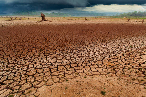 istock thunder storm sky Rain clouds Cracked dry land without wate 1165645009