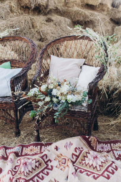 istock Wedding asymmetrical stylish bouquet with roses on a boho wicker chair. 1165645345