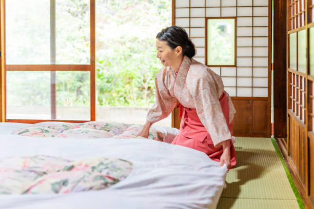 japanese woman making a traditional futon bed - estalagem imagens e fotografias de stock