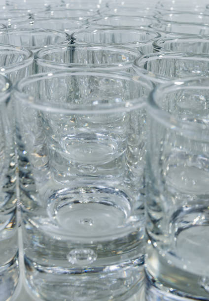 istock Vertical image of transparent glass cups on a white background - Luxurious and shiny cups 1165651371