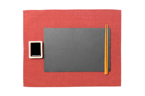 istock Empty rectangular black slate plate with chopsticks for sushi and soy sauce on red napkin background. Top view with copy space for you design 1165657176