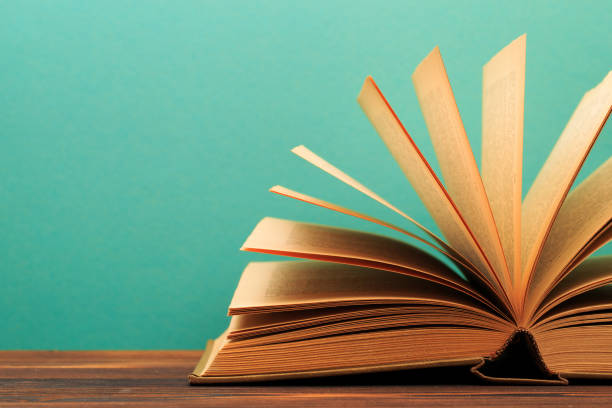 istock Open book on wooden vintage table blue background - Image 1165657380
